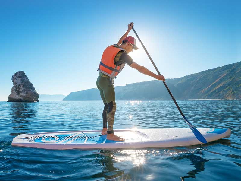 Die richtige SUP-Technik für Anfänger:innen - im Stehen Eine Hand gehört an den Griff und eine an den Paddelschaft – du paddelst also immer mit beiden Händen!