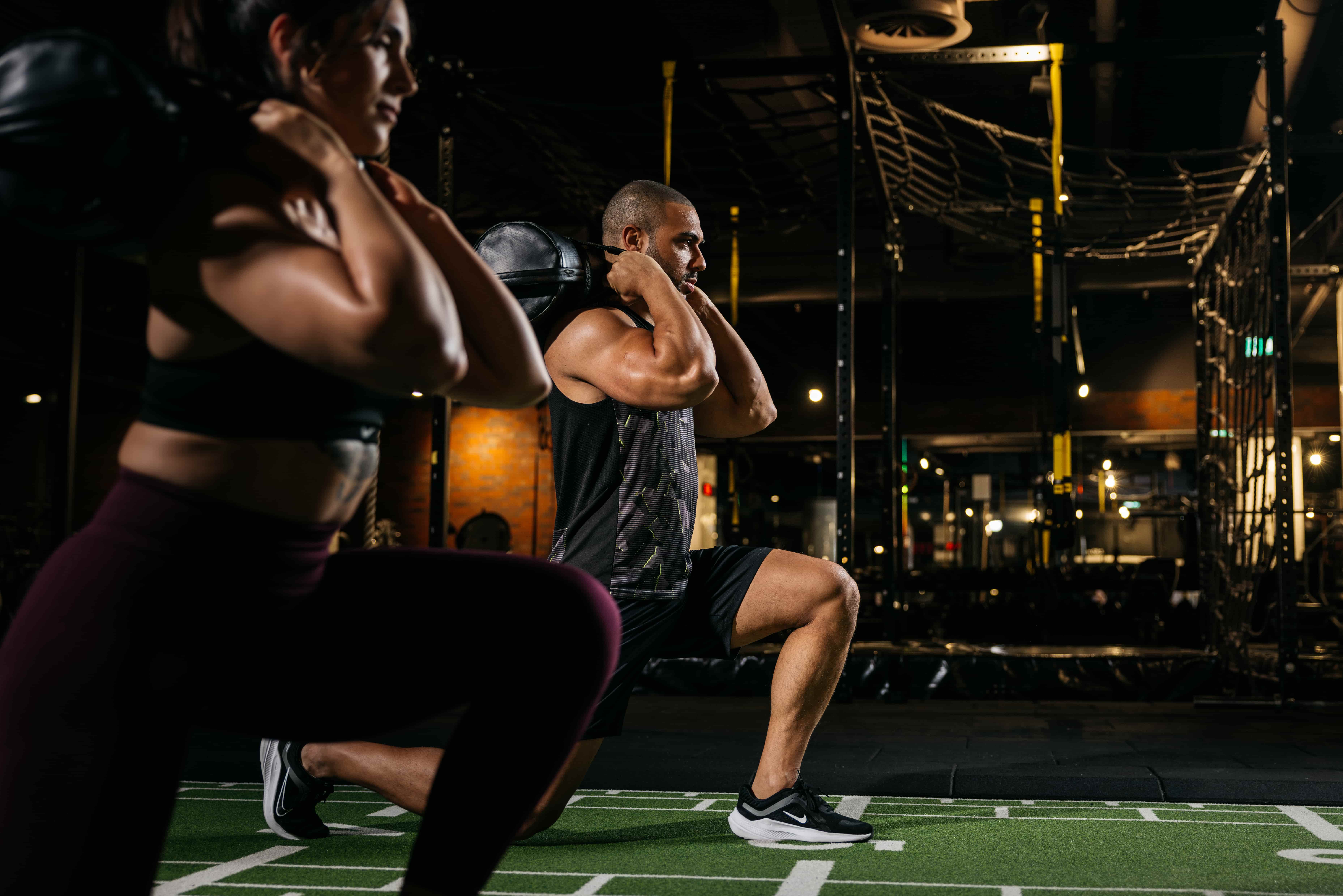 Paar macht Sandbag Lunges