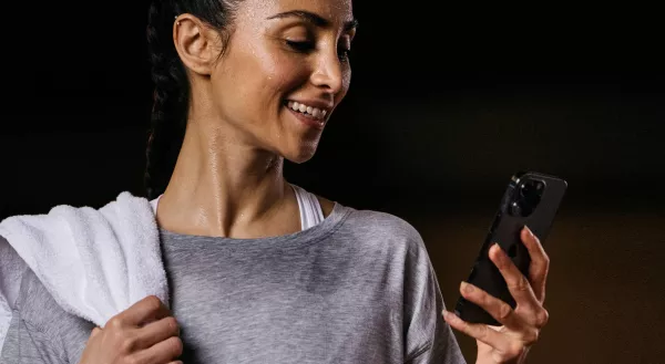 Fitness First Frau schaut auf Handy