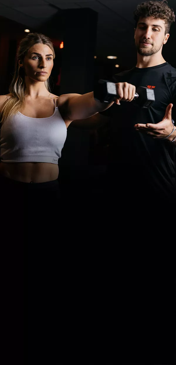 Fitness First Trainer betreut Mitglied