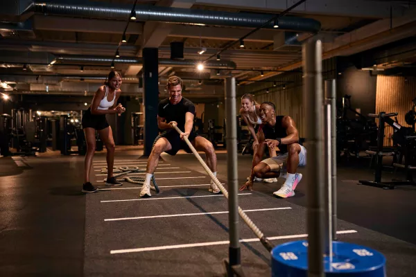 Freunde feuern Mann beim Sled Pull an.