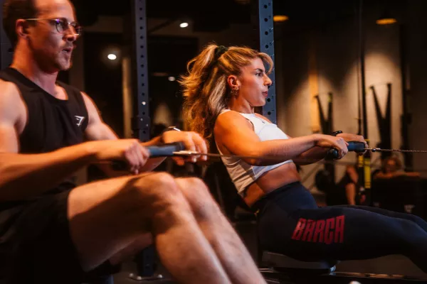 Junges Paar trainiert am Ruderergometer