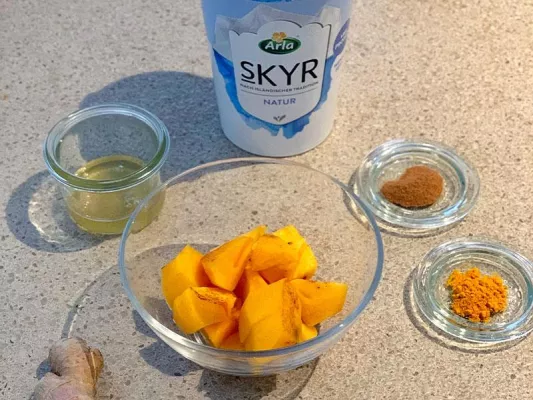 500 g Skyr, 1 Kaki, geschält, 1/2 TL Zimt, 1/2 TL Kurkuma, 1 Prise Pfeffer, 1 Scheibe Ingwer, 2-3 EL Reissirup