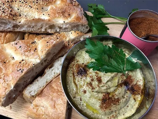 Fülle den Dip in eine oder mehrere Schalen und beträufle ihn mit Sumach, Petersilie sowie etwas Olivenöl.