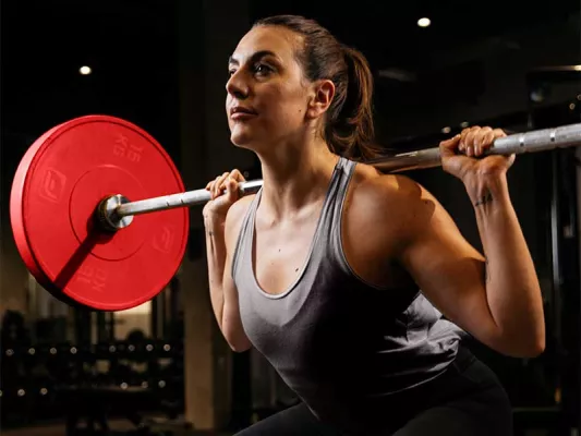 Die sogenannten Back Squats sind Kniebeugen mit der Langhantel hinter deinem Kopf.