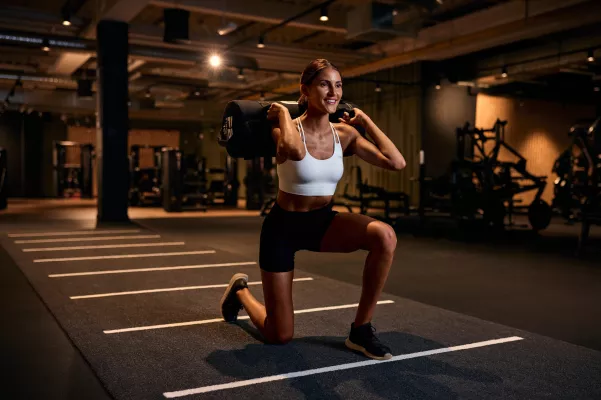 Junge Frau macht Sandbag Lunges